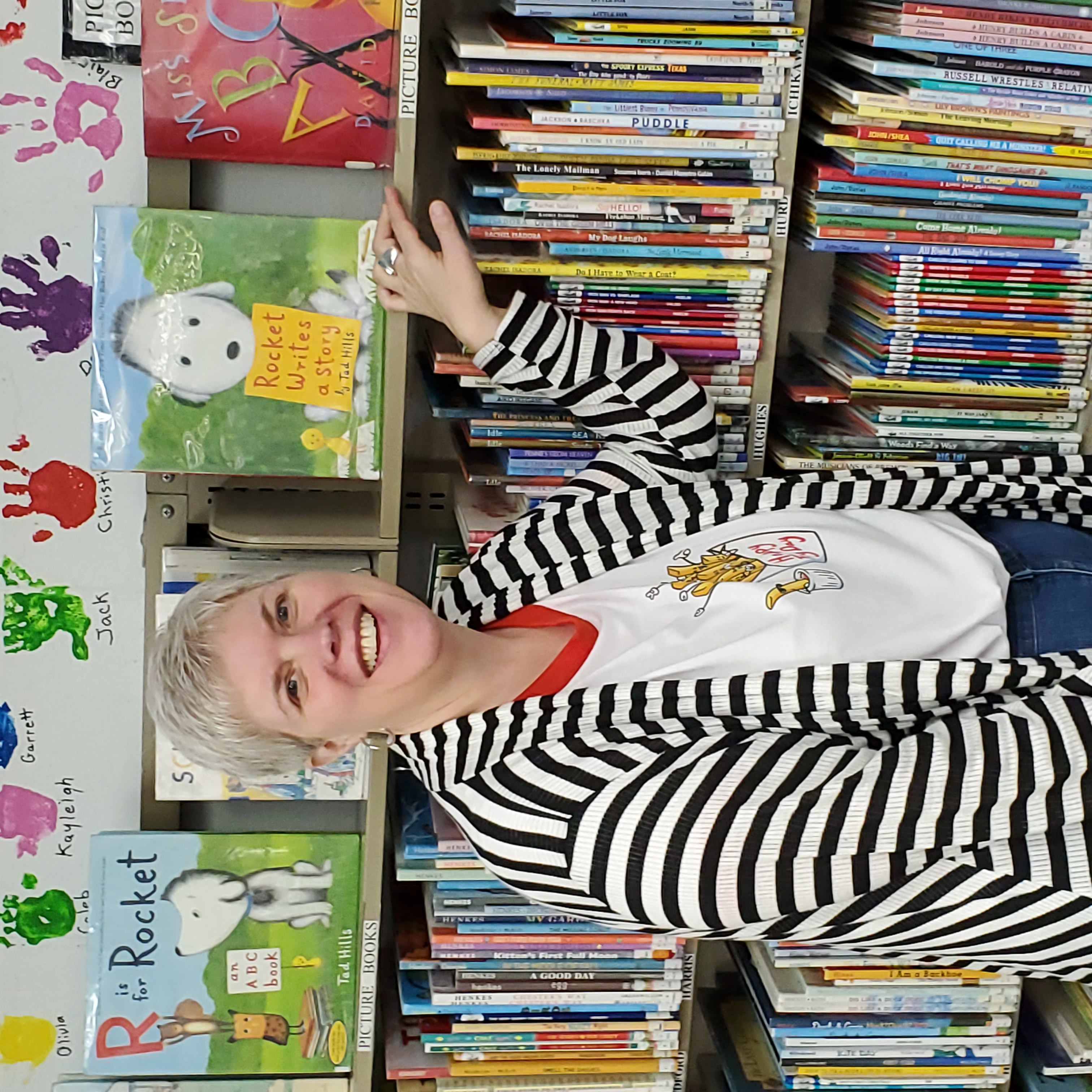 Jennifer Johnson-Spence standing in front of a shelf of children's books in her library.